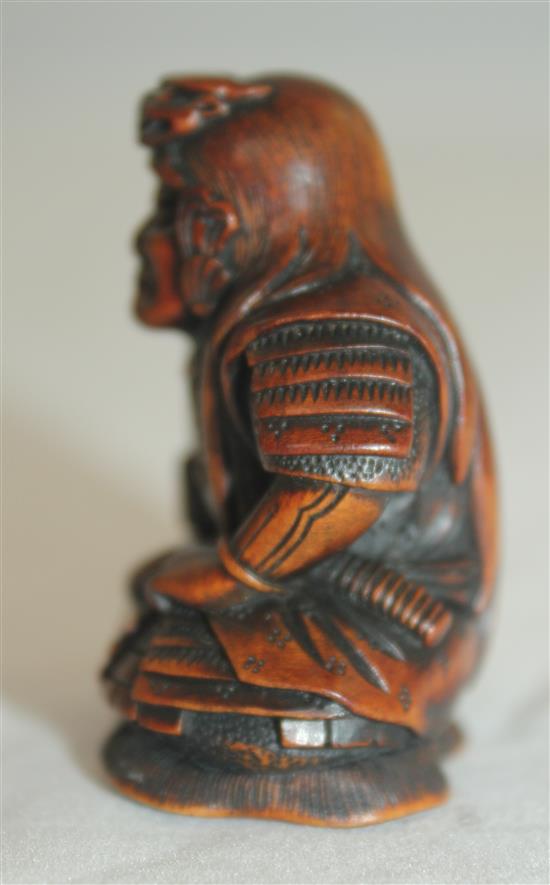 A Japanese boxwood netsuke of a seated Samurai General, late 19th century, 4.5cm